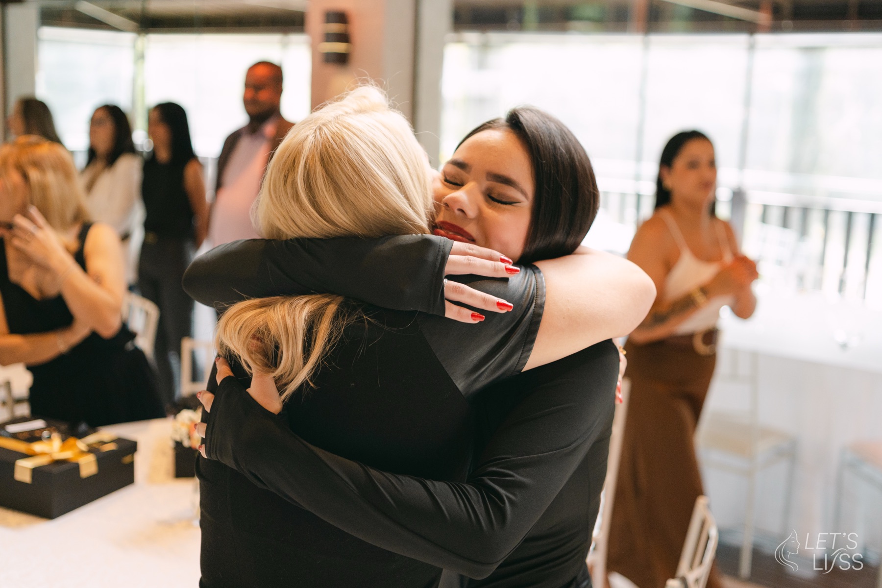 Duas colegas se abraçando emocionadas na convenção