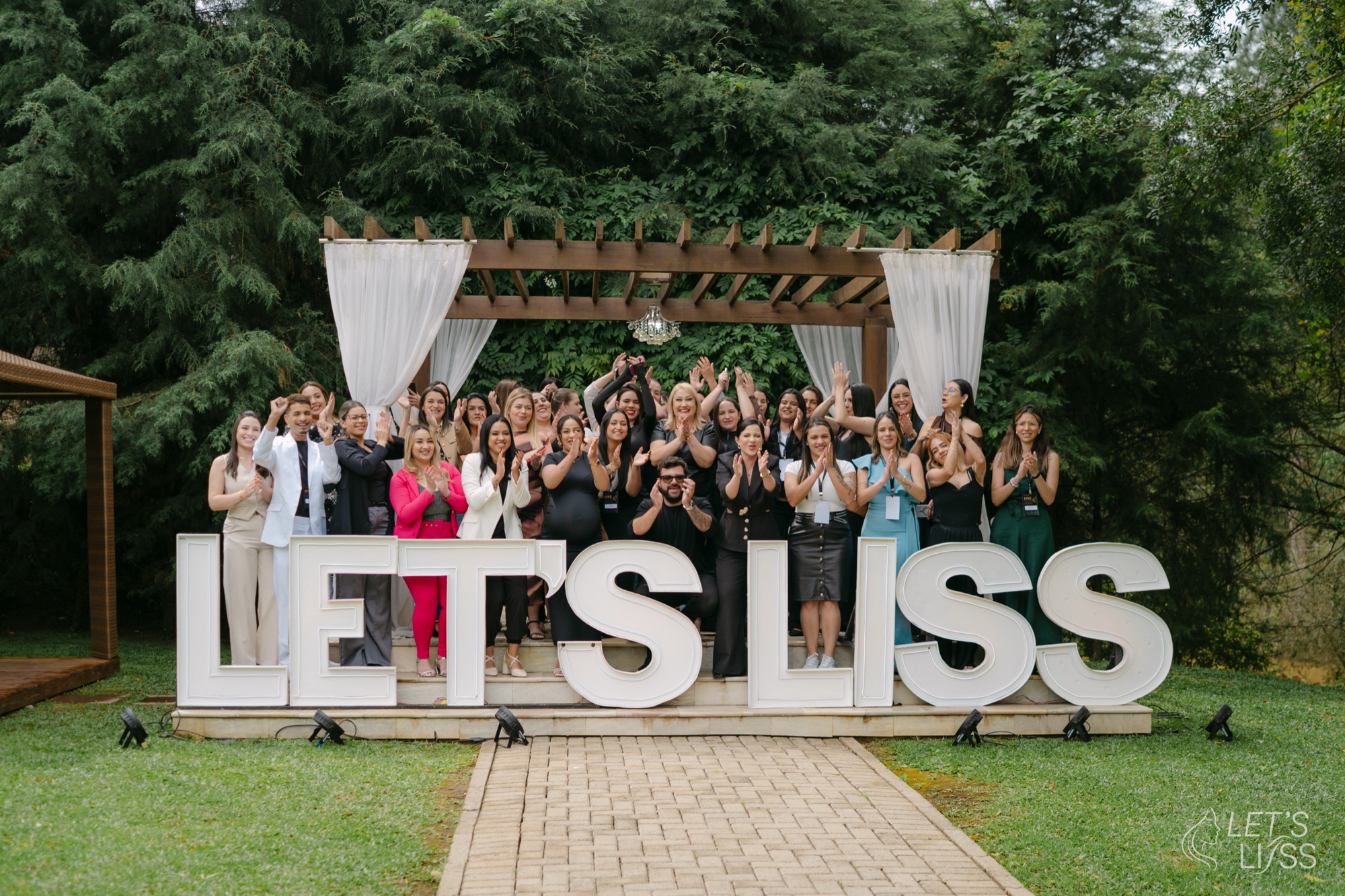 Time Let's Liss reunido diante das letras LET'S LISS